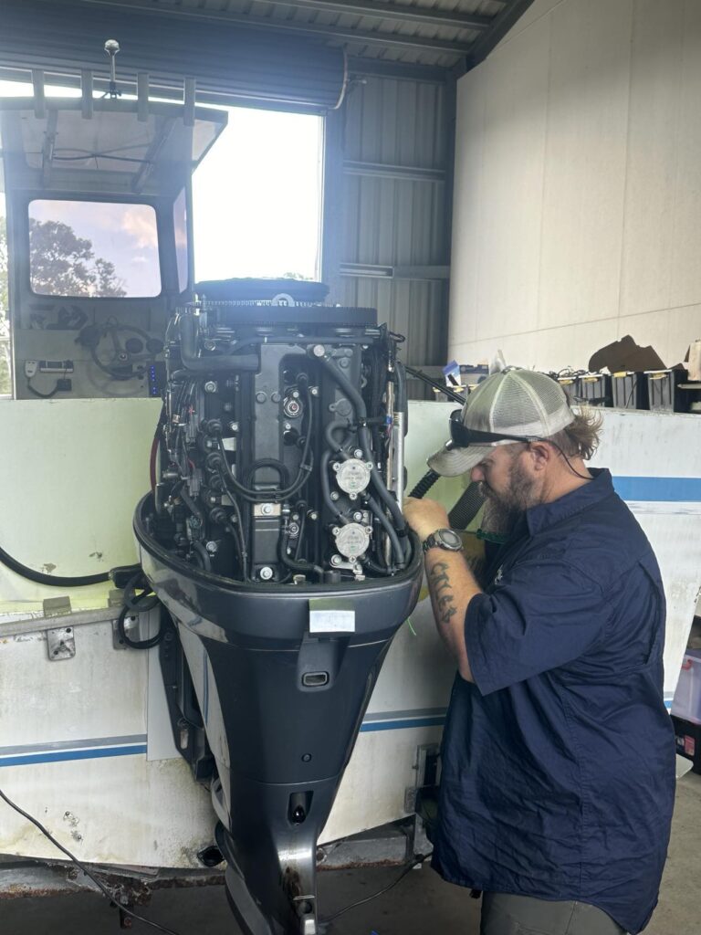 Man Repairing a Boat Engine in A Garage Workshop — Secondhand Boat Motors in Hervey Bay
