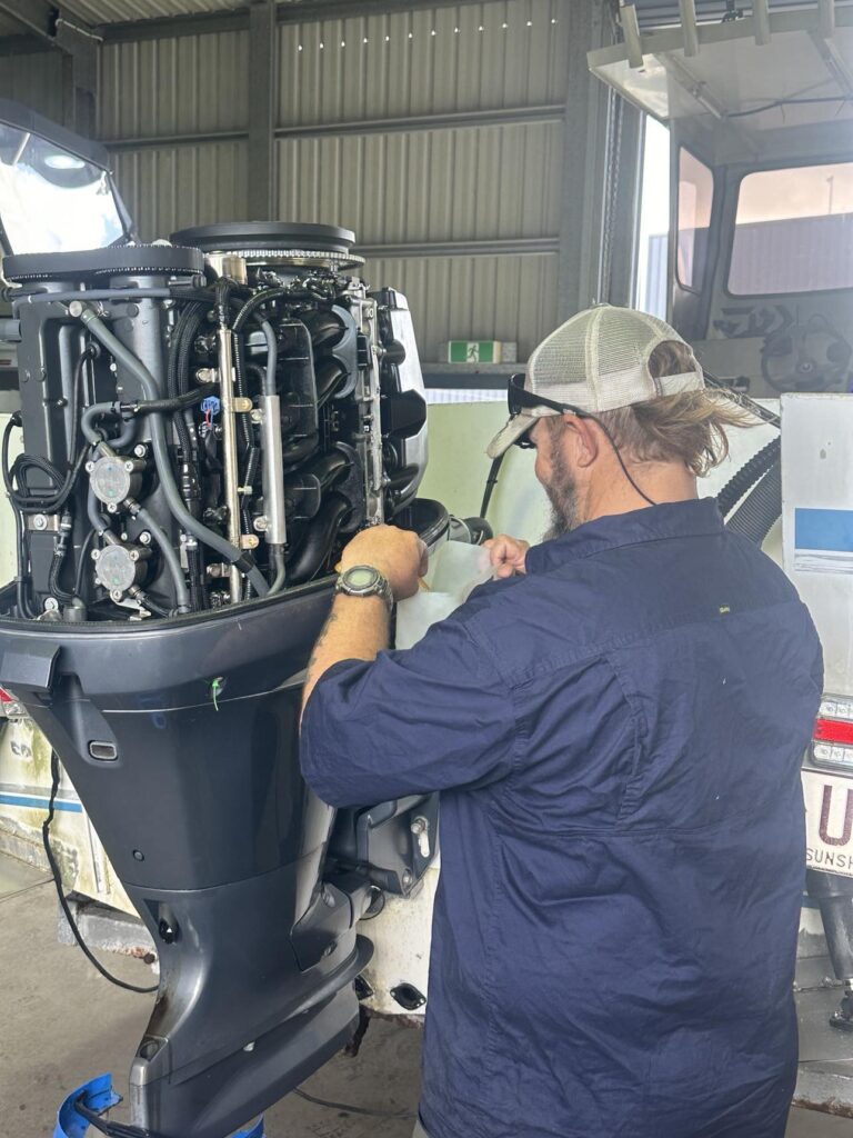 A Mechanic Diligently Repairs a Boat Engine in A Workshop — Secondhand Boat Motors in Hervey Bay